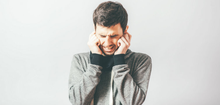 Man covering ears feat