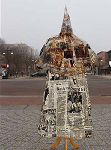 A professor was required to remove his artwork — a Ku Klux Klan robe covered in newspaper images of racial violence — from an open area of campus.